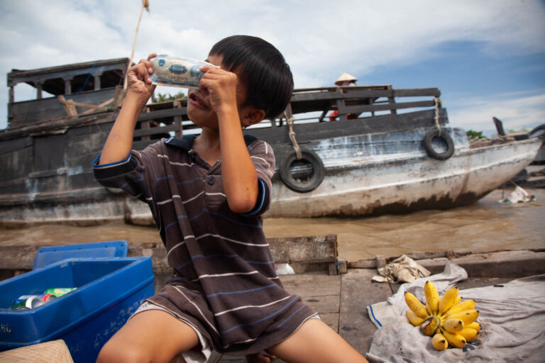 Boy waving cash on the Mekong River Vietnam