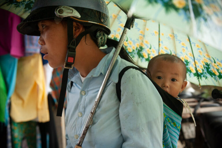 Young Vietnamese woman with a baby in a backpack in Mai Chau, Vietnam